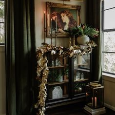 a living room decorated for christmas with greenery on the mantle and window sill