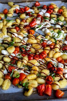 a pizza covered in lots of different types of toppings on top of a pan