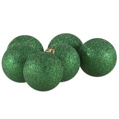 four green glittered ornaments on white background