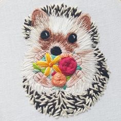 an embroidered hedge with flowers in its mouth