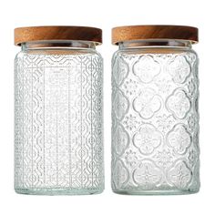 two glass jars with wooden lids on white background