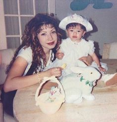 two women and a baby sitting at a table with an easter bunny in front of them