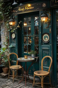 two wicker chairs sitting at a small table in front of a green door