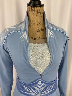 the back of a blue dress with white snowflakes on it