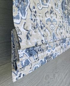 an upholstered headboard with blue and beige floral designs on it's sides