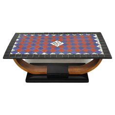 an artistically designed coffee table with wood base and geometric design on the top, against a white background