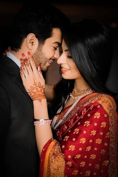 a man and woman with their hands on each other's chests, both wearing hennap