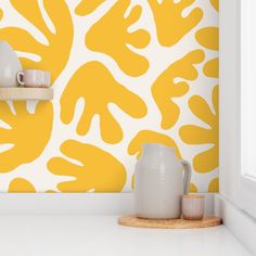 a yellow and white wallpaper with two vases on the shelf next to it