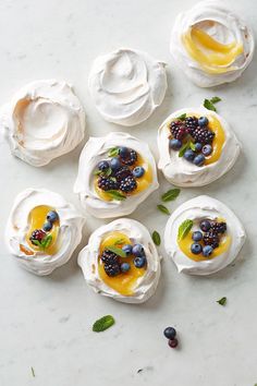 small desserts with fruit on them are arranged in the shape of flowers and leaves