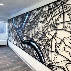 a large black and white mural on the wall in an office space with two couches