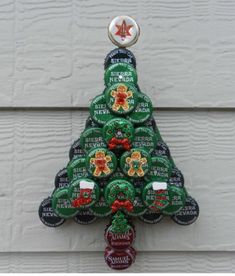 a christmas tree shaped bottle cap ornament hanging on the side of a building