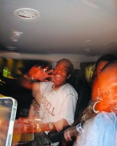 a group of people standing around each other in the back of a car at night