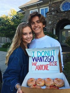 a young man and woman are holding a box of donuts that says i donut want to please anyone else