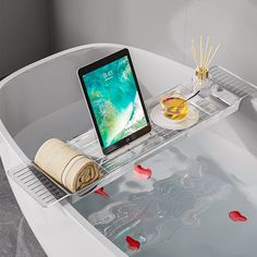 a tablet computer sitting on top of a bath tub