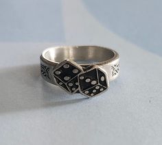 This ring was designed with the casino dice symbol. The beautiful pewter ring is a silver color and the background is blackened to bring out the fine detail of the design. Our rings are 100% Lead and nickel free pewter and made in the USA The top design part of the ring measures approx. 12.5mm x 8.5mm  The ring band tapers from about 5mm to about 4mm at the bottom and is about 1.5mm thick Picture shows size compared to a US Dime Rings are available in sizes 4 to 7 (half sizes also) Pewter Ring, Ladies Ring, Top Design, Ring Band, Rings Statement, Women Rings, Band Rings, Silver Color, Statement Rings