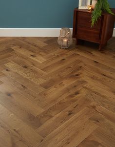 an empty room with wood flooring and a lamp on the side table next to it