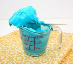 a blue plastic blender sitting on top of a yellow table cloth next to a white wall