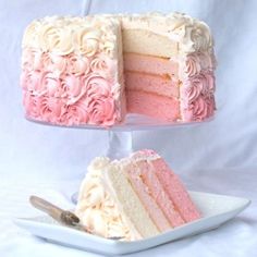 a pink and silver baby shower cake on a white plate with a serving fork in front of it