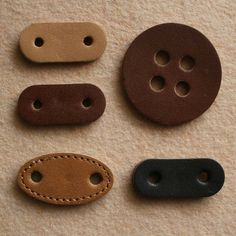 four leather buttons with stitching on them