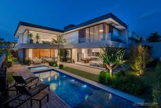 a large house with a swimming pool in the middle of it's yard at night