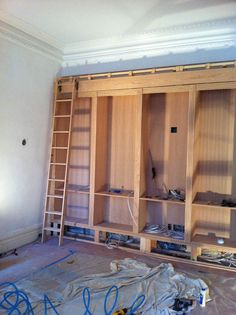 an unfinished closet with shelves and ladders in the middle of being built into the wall