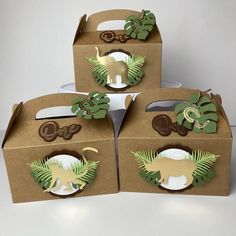 four brown boxes with green and white paper cutouts on them, each containing an animal