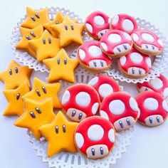 some cookies are shaped like mario bros stars and mushroom ones on a plate with lace doily