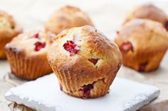 muffins with fresh strawberries sitting on a napkin