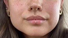 a woman with freckles and piercings on her nose