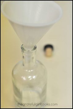 an empty glass bottle with a white cone on top