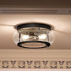 a ceiling light that is hanging from the ceiling in a room with wallpaper on the walls