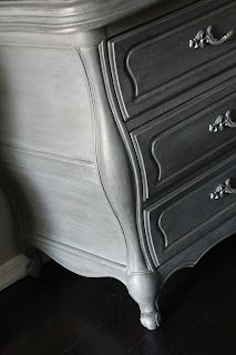 an antique dresser with silver paint on it's top and drawers, in a bedroom