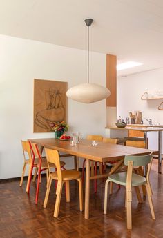 a dining room table with chairs and a painting on the wall