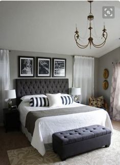 a bedroom with a large bed and chandelier in the corner, along with pictures on the wall