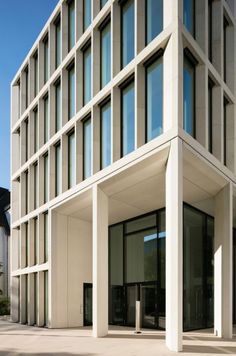 an office building with many windows on the front and side of it's facade