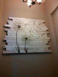 a wooden wall hanging with dandelions painted on it