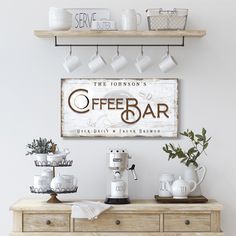 a coffee bar sign hanging on the wall above a wooden table with cups and mugs