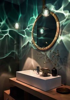 a bathroom with a sink, mirror and lights on the wall in it's corner