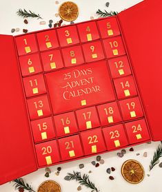 a red calendar sitting on top of a table next to oranges and pine cones