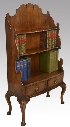 an old wooden bookcase with books on it's sides and two drawers below