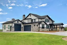 a large house sitting in the middle of a lush green field next to a road