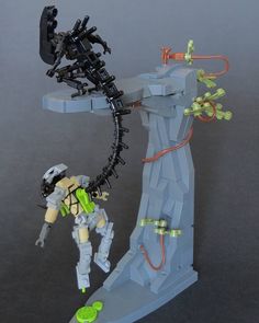 an action figure made out of legos on top of a black surface with wires