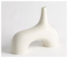 a white vase sitting on top of a table