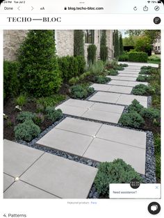 an image of a stone walkway in front of a house with trees and bushes on each side