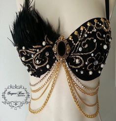 a close up of a mannequin wearing a black bra with gold chains and pearls