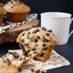 a muffin with chocolate chips on it and a cup of coffee