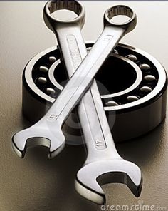 two wrenches are sitting on top of each other next to a roller bearing unit