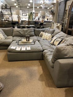 a large sectional couch in a store with lots of pillows