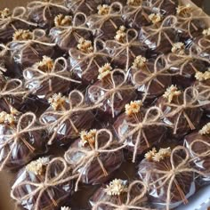 chocolates wrapped in twine and tied with jumbo sticks are displayed on a plate