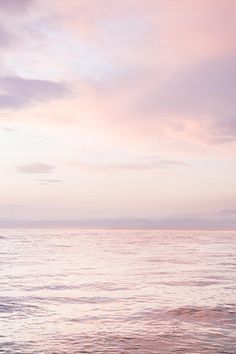 two people walking on the beach at sunset